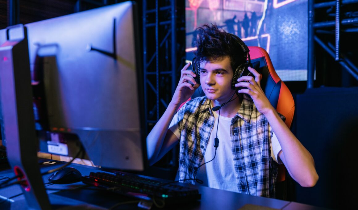 teenager wearing headphones in front of a computer