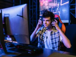 teenager wearing headphones in front of a computer